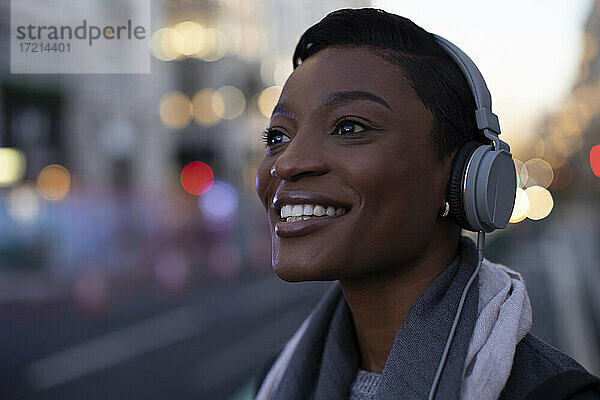 Close up Porträt glückliche junge Frau in Kopfhörer auf Stadt Straße