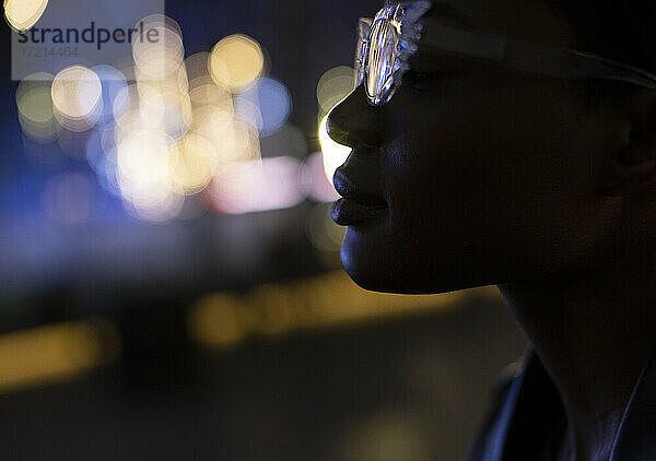 Close up Profil junge Frau in stilvolle Brille in der Nacht