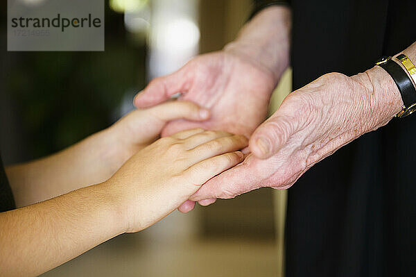 Nahaufnahme von Großmutter und Enkelin (8-9) beim Händchenhalten