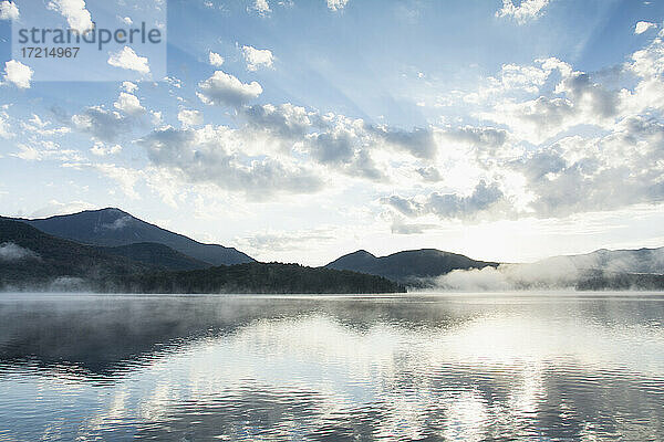 Vereinigte Staaten  New York  Lake Placid  Berge und Wolken reflektiert in ruhigen Lake Placid bei Sonnenaufgang