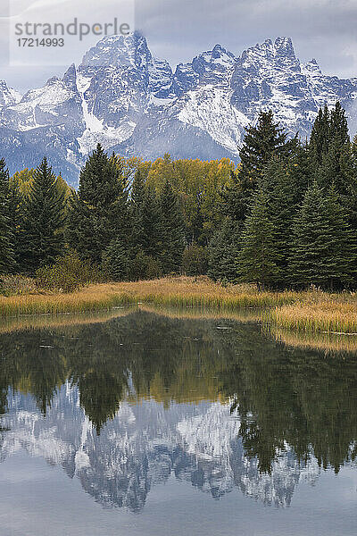 Vereinigte Staaten  Wyoming  Schnee bedeckt Teton Berge und Bäume in ruhigen See reflektiert