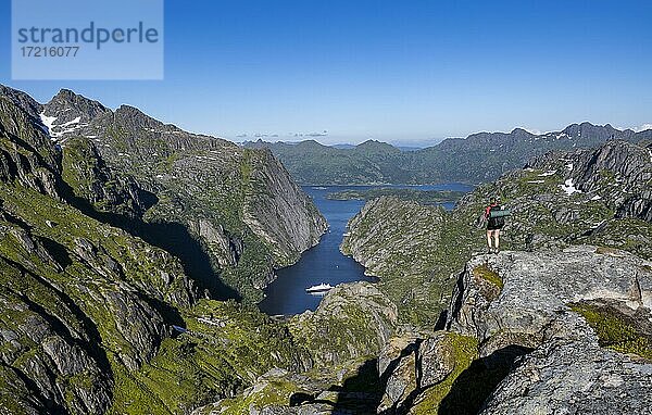 Junge Frau beim Wandern  Berge und Schnee  Wanderung zur Trollfjord Hytta  Ausblick auf Trollfjord und Raftsund  Lofoten  Nordland  Norwegen  Europa