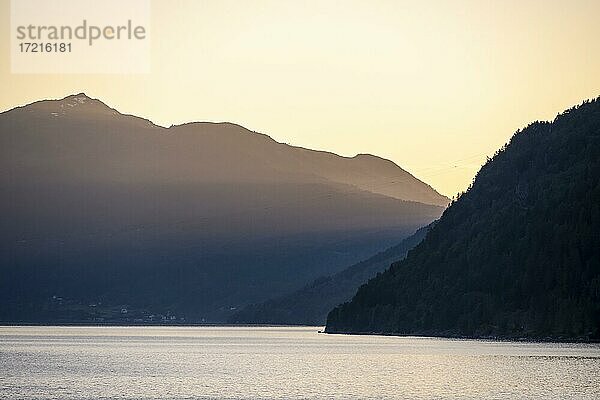 Abendstimmung  Sonne scheint über Berge und Hügel am Fjord Innvikfjorden  Norwegen  Europa
