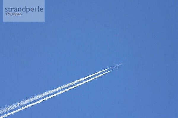 Flugzeug mit Kondensstreifen am blauen Himmel  Deutschland  Europa
