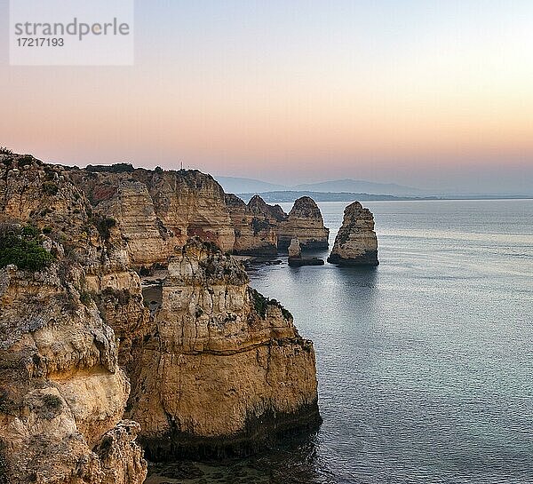 Schroffe Felsenküste mit Klippen aus Sandstein  Felsformationen im Meer  Ponta da Piedade  Morgenrot  Algarve  Lagos  Portugal  Europa