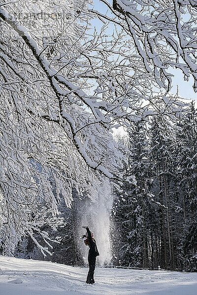 Frau genießt beim Winterspaziergang den Schnee  Winter mit Schnee  verschneite Landschaft  Bad Heilbrunn  Oberbayern  Bayern  Deutschland  Europa