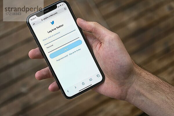 Hand hält iPhone 11 Pro mit geöffneter Twitter Website  Login  Soziales Netzwerk  Logo  Smartphone