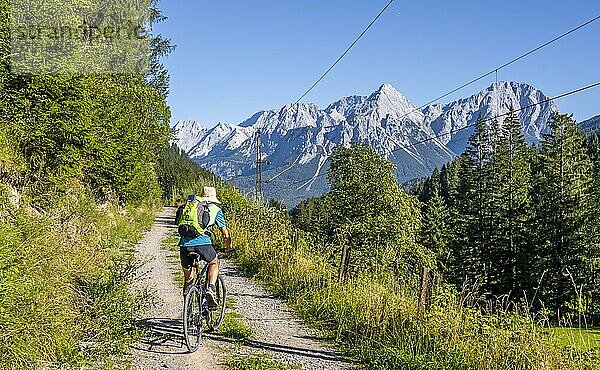 Fahrradfahrer auf Radtour mit Mountainbike  auf dem Radweg Via Claudia Augusta  hinten Ehrwalder Sonnenspitze  Ehrwalder Becken  bei Ehrwald  Tirol  Österreich  Europa