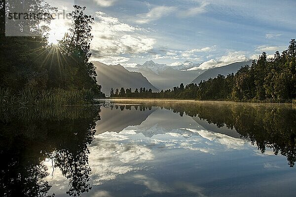 Ausblick auf Mount Cook im Morgenlicht mit Sonnenstern  Spiegelung im Lake Matheson  Westland Nationalpark  Neuseeländische Alpen  Region West Coast  Südinsel  Neuseeland  Ozeanien