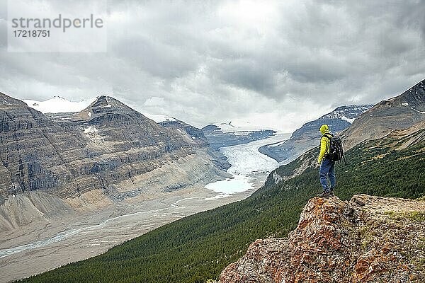 Wanderer steht auf Felsen mit Ausblick in Tal mit Gletscherzunge  Parker Ridge  Saskatchewan Gletscher  Athabasca Gletscher  Jasper National Park Nationalpark  Canadian Rocky Mountains  Alberta  Kanada  Nordamerika