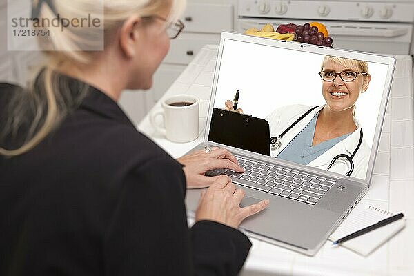 Frau in Küche mit Laptop  Online-Chat mit Krankenschwester oder Ärztin auf dem Bildschirm