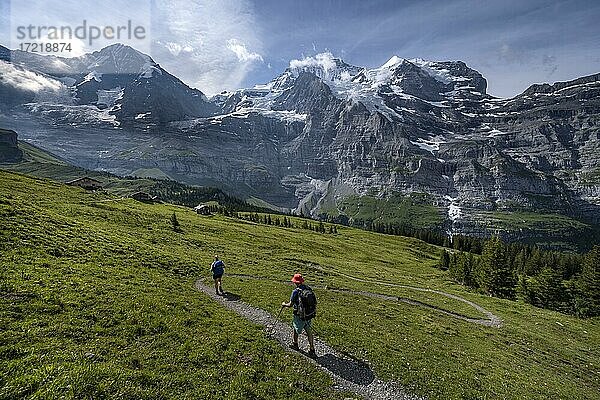 Zwei Wanderer auf einem Wanderweg  vor der Eiger Nordwand  hinten Berge und Berggipfel  Steilwand und Berge  Jungfrauregion  Lauterbrunnen  Berner Alpen  Schweiz  Europa