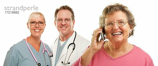 Glückliche ältere Frau mit Handy mit Arzt  Ärztin oder Krankenschwester  Krankenpfleger vor weißem Hintergrund