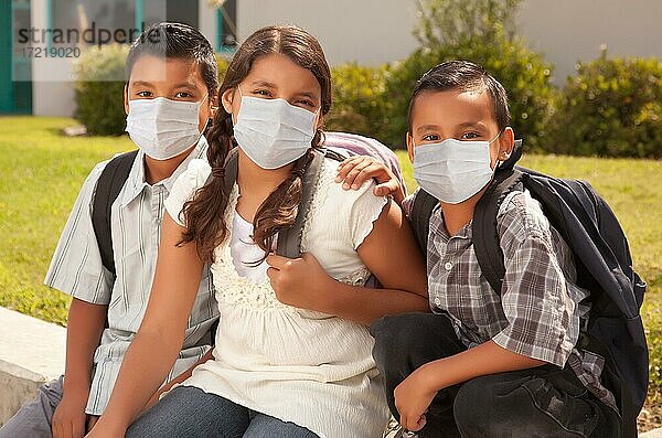 Junge hispanische Studenten auf dem Schulcampus  die medizinische Gesichtsmasken tragen  USA  Nordamerika