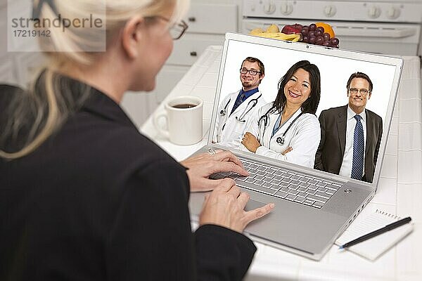 Blick über die Schulter einer Frau in der Küche mit Laptop Online-Chat mit Krankenschwestern oder Ärzten auf dem Bildschirm