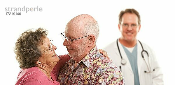 Glückliches liebevolles älteres Paar mit lächelndem Arzt oder Krankenpfleger vor weißem Hintergrund