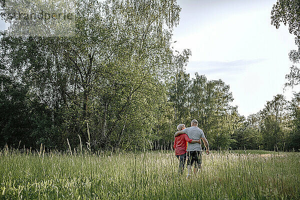 Älteres Paar geht entlang eines Feldes