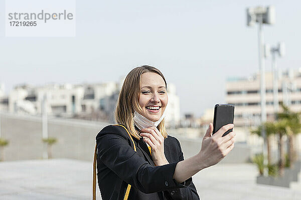 Lächelnde Unternehmerin  die ein Selfie mit ihrem Smartphone macht