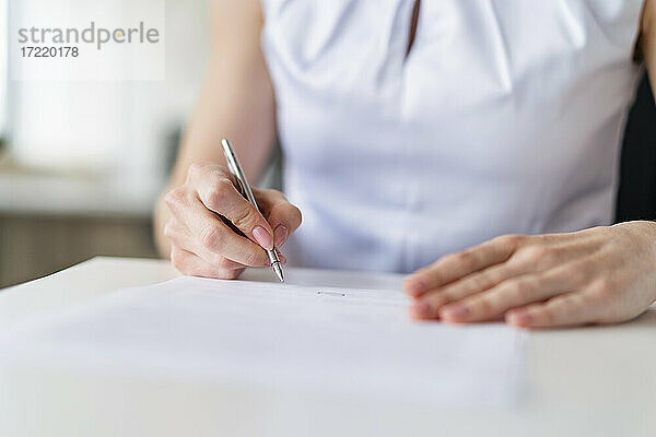 Geschäftsfrau bei der Vertragsunterzeichnung im Büro