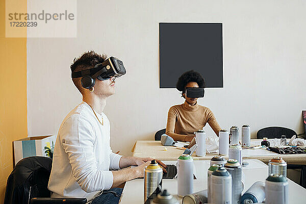 Junges Paar trägt Virtual-Reality-Simulator bei der Arbeit im Studio