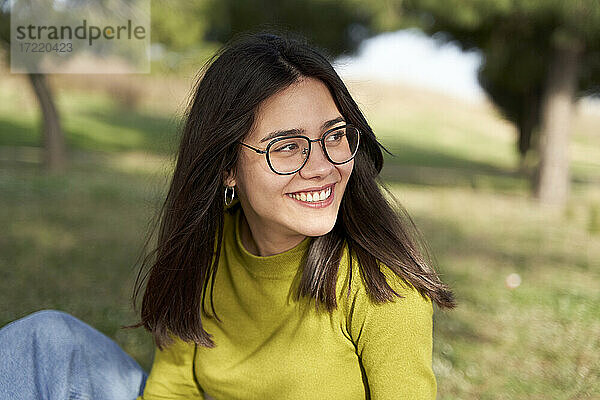 Lächelnde Frau mit Brille schaut weg