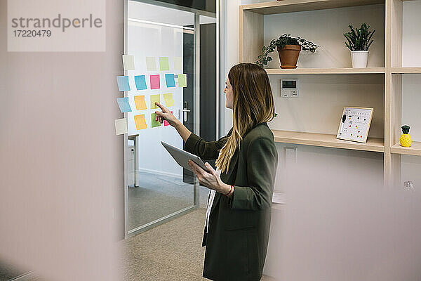 Eine Unternehmerin beim Brainstorming mit einem digitalen Tablet im Büro