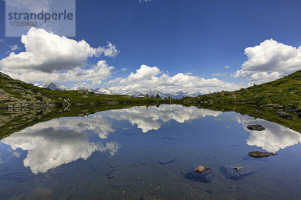 Wolken spiegeln sich in einem kleinen glänzenden See im Speikboden-Massiv