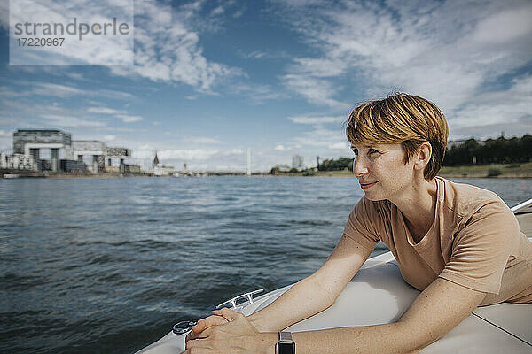 Frau mit kurzen braunen Haaren schaut weg  während sie in einem Motorboot unterwegs ist