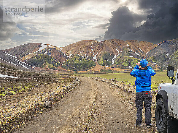 Männlicher Reisender  der die vulkanische Landschaft von Landmannalaugar fotografiert