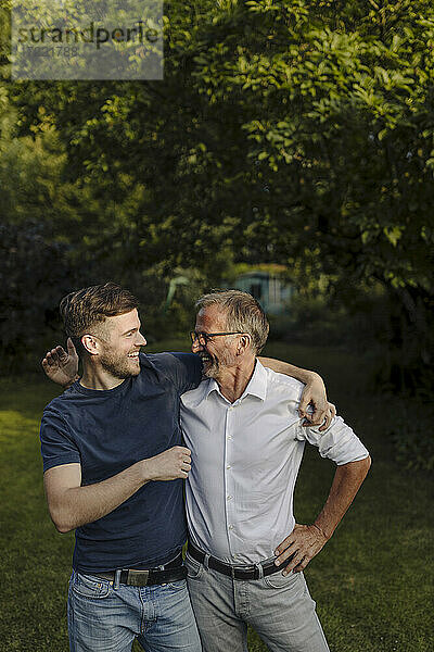 Glücklicher Vater und Sohn schauen sich an  während sie im Hinterhof stehen