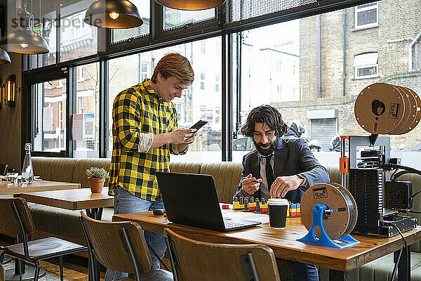 Männliche Unternehmer diskutieren bei der Arbeit im Büro über 3D-Druckspiele