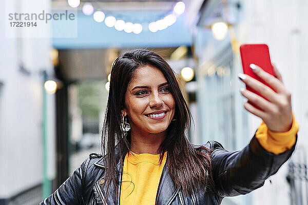 Schöne Frau lächelnd während der Aufnahme selfie auf Handy in der Stadt