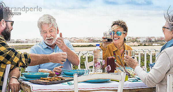 Glückliche Familie beim Mittagessen an einem sonnigen Tag