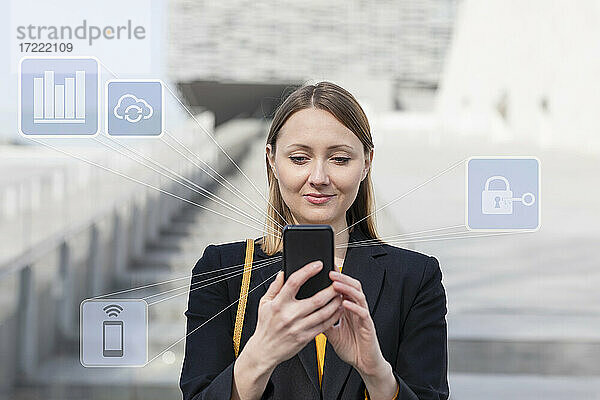 Geschäftsfrau  die ein Mobiltelefon benutzt  während sie mit einem Netzwerksymbol im Freien steht