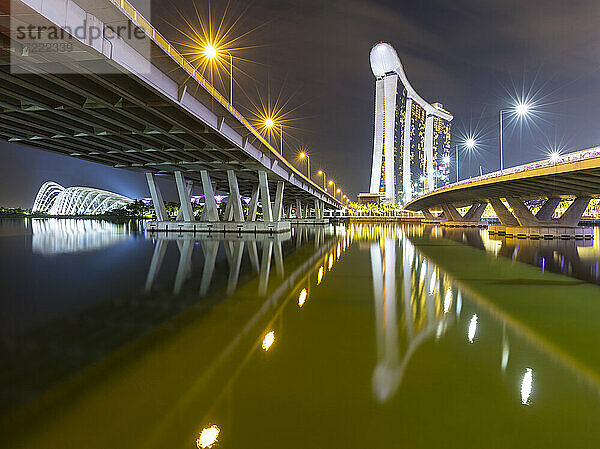 Singapur  Blick zwischen Bayfront Bridge und Benjamin Sheares Bridge bei Nacht mit Marina Bay Sands im Hintergrund