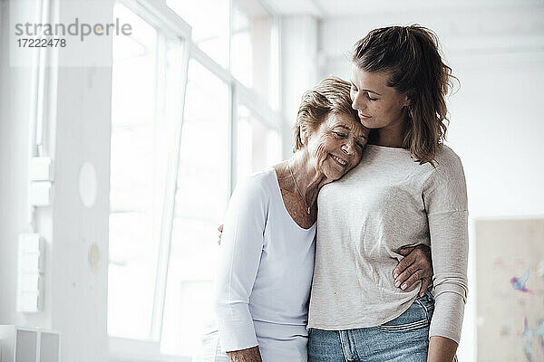 Pflegende Großmutter umarmt Frau zu Hause