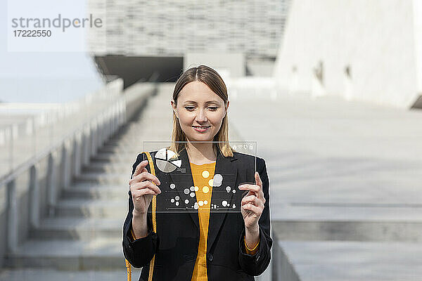 Geschäftsfrau mit futuristischem digitalen Tablet im Freien