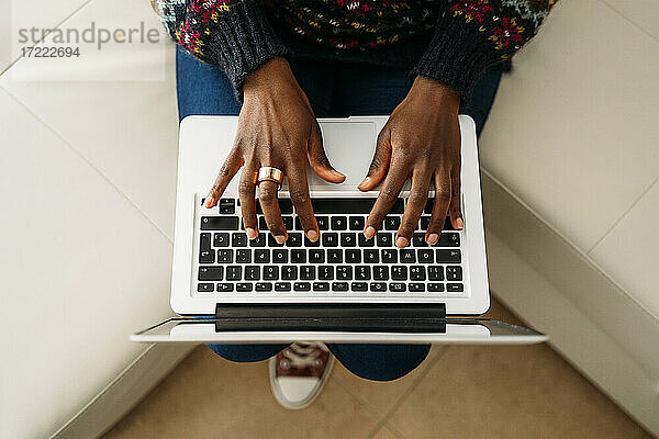 Junge Geschäftsfrau arbeitet zu Hause am Laptop