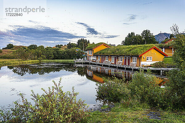 Norwegen  Vega-Archipel  Überwuchertes Haus mit Spiegelung im kleinen Teich
