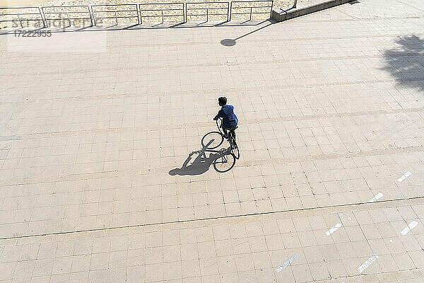 Mann fährt Fahrrad auf der Promenade an einem sonnigen Tag