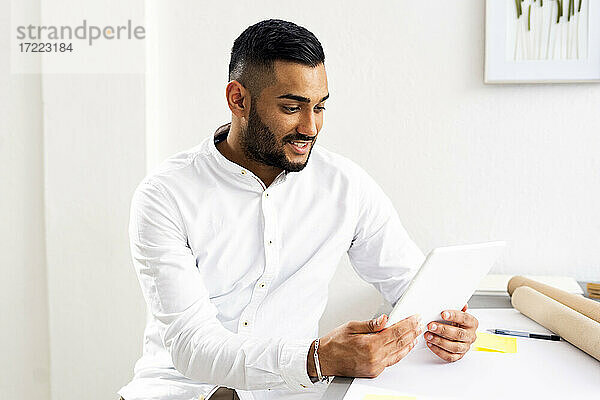 Geschäftsmann mit digitalem Tablet auf dem Schreibtisch im Büro