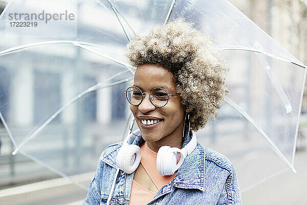Lächelnde Frau mit Brille und Regenschirm