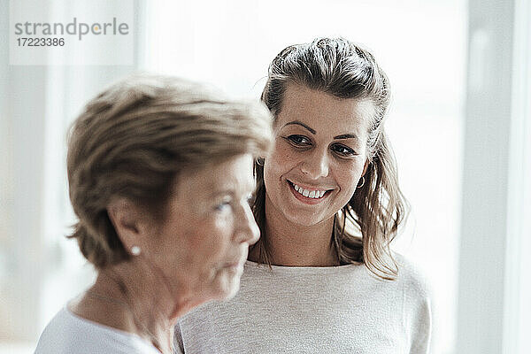 Lächelnde Frau mit braunem Haar  die ihre Großmutter anschaut