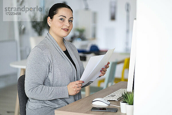 Geschäftsfrau hält Dokumente bei der Arbeit im Home Office