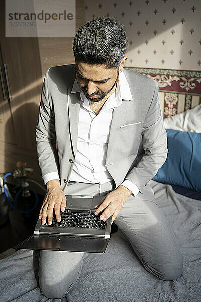 Männlicher Berufstätiger  der zu Hause am Laptop arbeitet