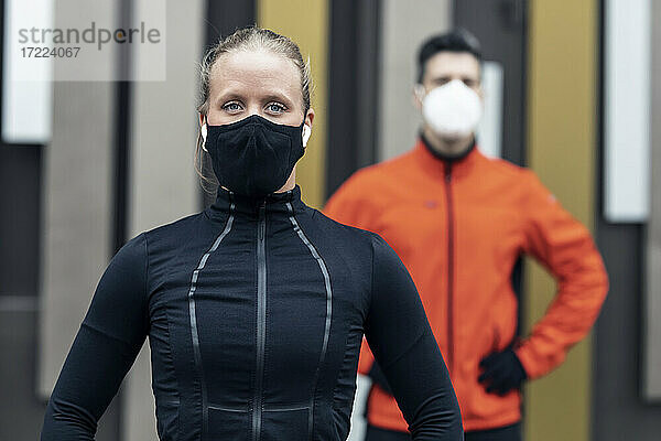 Männliche und weibliche Freunde mit Schutzmasken und Sportkleidung während der Pandemie