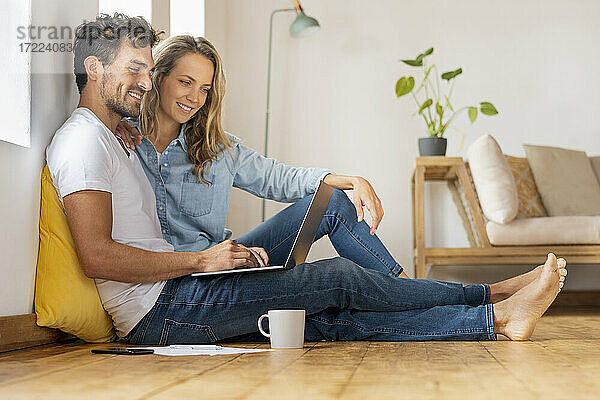 Entspanntes Paar  das im Home Office zusammensitzt und auf den Laptop schaut