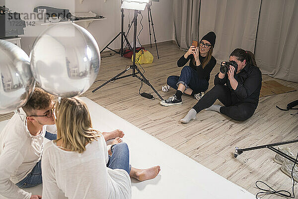 Weibliche Fotografen fotografieren ein Paar im Studio