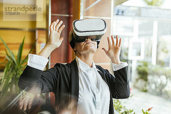 Weiblicher Geschäftsmann mit Virtual-Reality-Simulator im Hotel