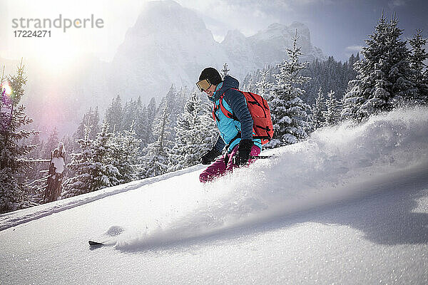 Skifahrerin auf einem verschneiten Berg an einem sonnigen Tag